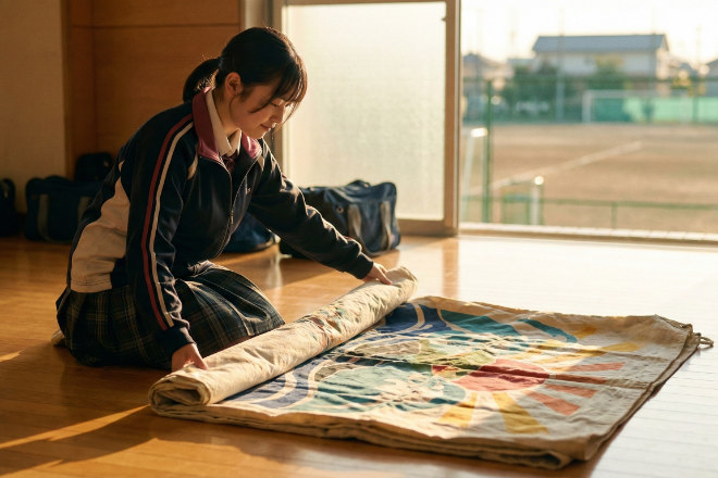 練習後に横断幕を丁寧にたたんで片付けている日本の女子マネージャー