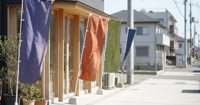 店頭に設置されたのぼり旗が風になびく様子